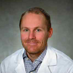Portrait of John Barett wearing a white lab coat