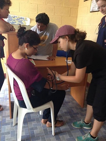 Penn Nursing student, Melanie Santos, taking a patient's blood pressure.