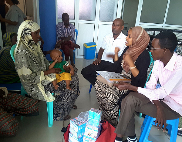 Nia speaking with a family whose child had a cleft lip and was malnourished.